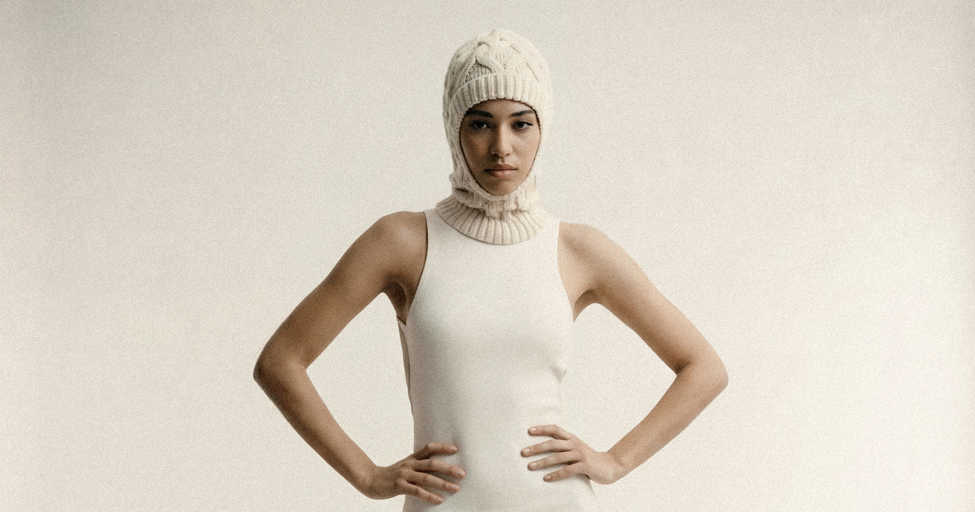 KI-produzierte Fashion-Kampagne: On-Model-Studioaufnahmen eines Strickaccessoires in monochromer Cream-Ästhetik.